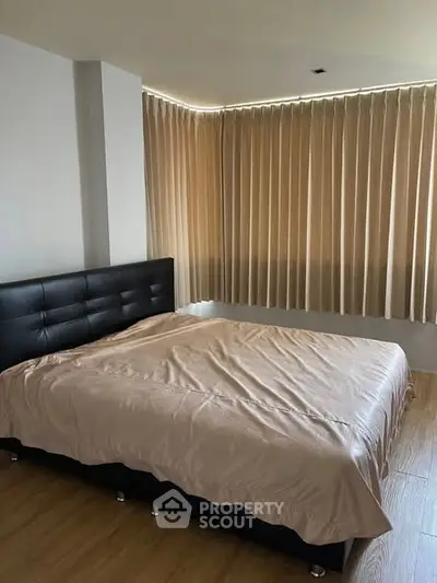 Spacious bedroom with elegant curtains and modern bed frame