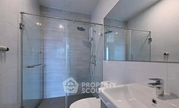 Modern bathroom with glass shower enclosure and sleek fixtures