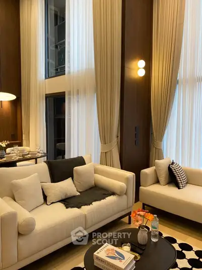 Luxurious high-ceiling living room with elegant decor and large windows