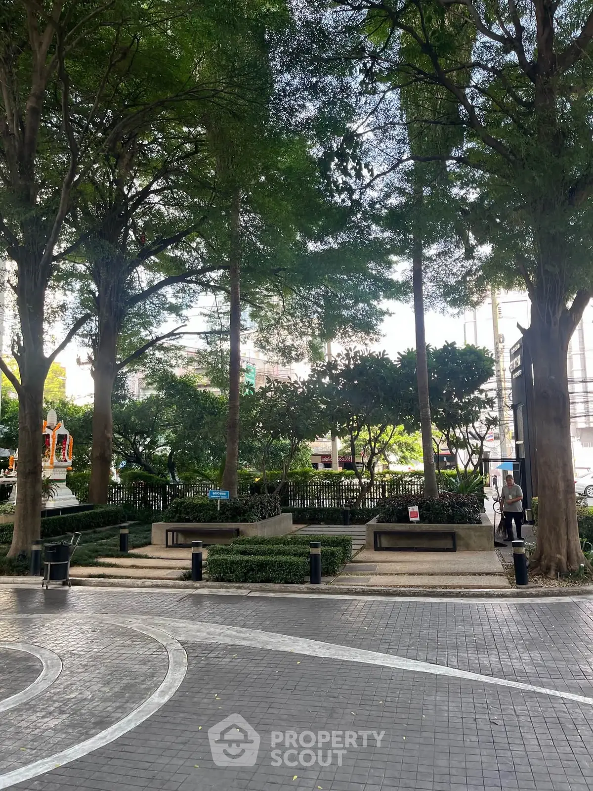 Charming urban garden with lush greenery and paved pathways, perfect for relaxation and outdoor enjoyment.