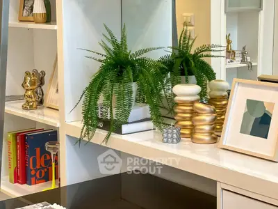 Stylish modern living room with decorative plants and art pieces on a sleek white shelf.