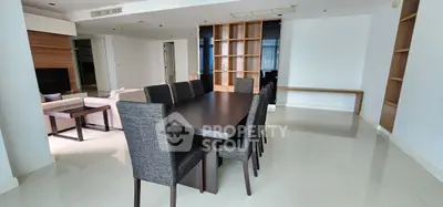 Spacious modern dining area with elegant dark wood table and chairs, open layout to living room.