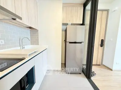 Modern kitchen with sleek appliances and stylish cabinetry in a contemporary apartment.