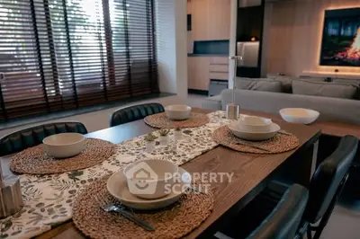 Modern dining area with stylish table setting and cozy living room view.