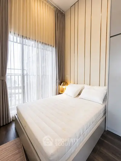 Luxurious bedroom with floor-to-ceiling windows and elegant decor in modern apartment.