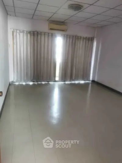 Spacious empty room with large windows and curtains, ideal for customization.