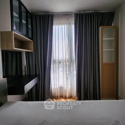 Cozy bedroom with modern furnishings and large window with elegant curtains