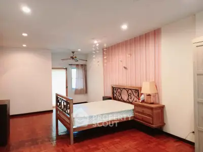 Spacious bedroom with wooden flooring and elegant decor