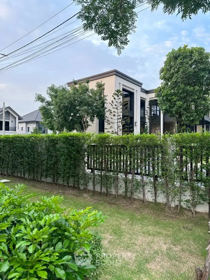 Modern luxury home exterior with lush garden and contemporary design.