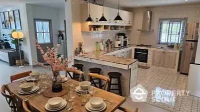 Modern open kitchen with dining area, featuring sleek appliances and stylish decor.