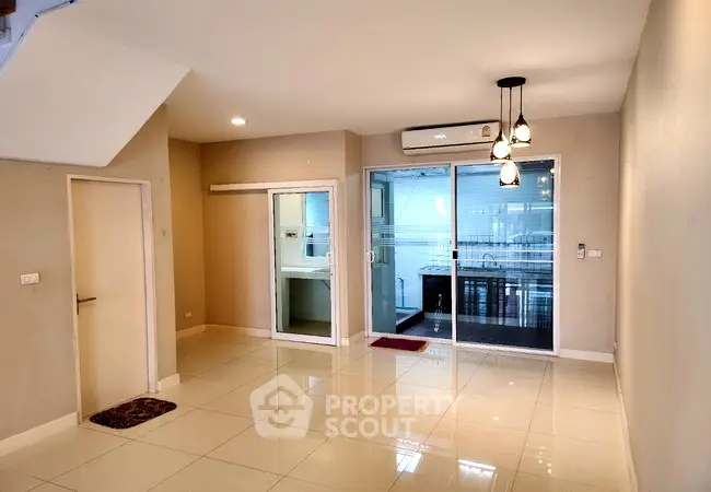Spacious modern living room with glossy tiled floors and glass sliding doors