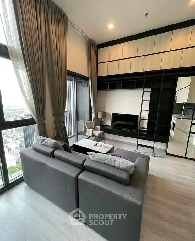 Modern living room with high ceilings, large windows, and stylish furniture in a luxury apartment.