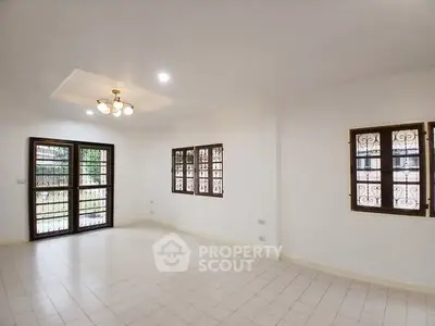 Spacious living room with large windows and elegant lighting in a modern home.