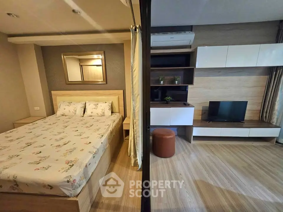 Modern studio apartment with cozy bedroom and stylish living area, featuring wooden flooring and contemporary decor.