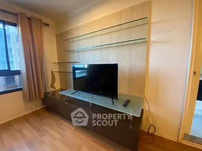 Modern living room with sleek TV stand and glass shelves, perfect for entertainment setup.