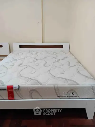 Spacious bedroom with a comfortable mattress on a stylish bed frame.