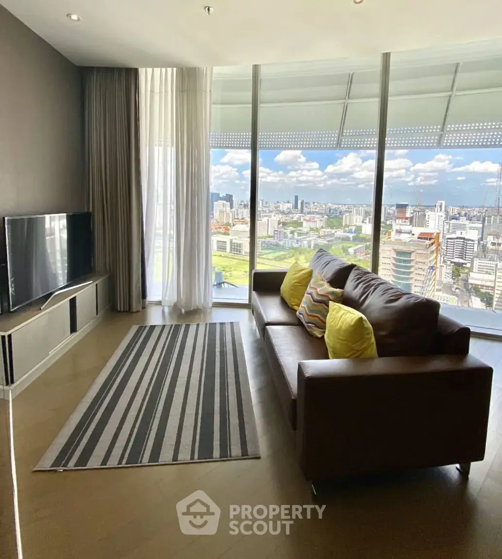 Modern living room with stunning city view, featuring sleek furniture and floor-to-ceiling windows.