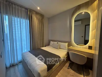Modern bedroom with stylish decor and large window offering natural light.