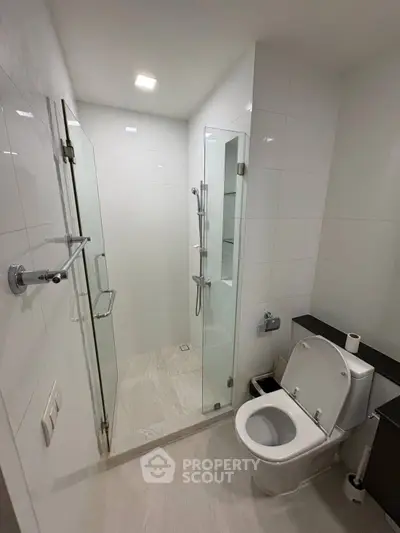 Modern bathroom with glass shower and sleek white fixtures