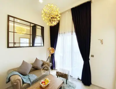 Elegant living room with modern chandelier and plush seating, featuring floor-to-ceiling windows and stylish decor.