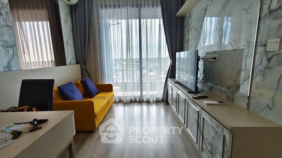 Modern living room with marble walls, large TV, and city view through sheer curtains.