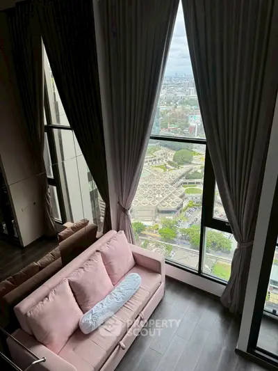Stunning high-rise living room with panoramic city view and elegant decor.