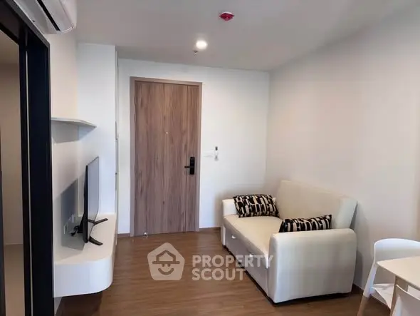 Modern living room with sleek furniture and wooden flooring in a cozy apartment.