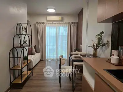 Modern living room with stylish decor and open kitchen layout, featuring elegant furniture and natural light.