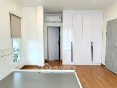Spacious bedroom with modern wardrobe and air conditioning in a bright, minimalist design.