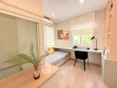 Modern study room with sleek desk, cozy daybed, and stylish decor in bright natural light.