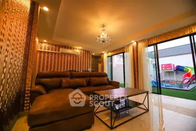 Luxurious living room with elegant chandelier and pool view, featuring plush sofa and modern decor.