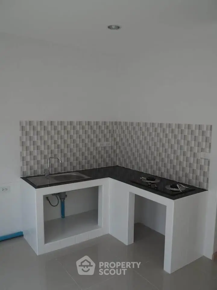 Modern minimalist kitchen with sleek black countertop and gas stove