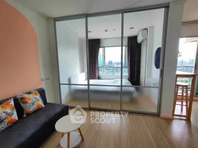 Modern apartment with glass partition, cozy living area, and stunning city view from bedroom.