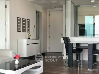 Modern living room with sleek furniture and open layout, featuring a stylish dining area and contemporary decor.