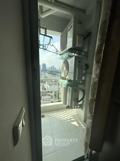 Compact balcony with city view and air conditioning units