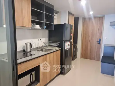 Modern kitchen with sleek wooden cabinets and stainless steel appliances in a stylish apartment.