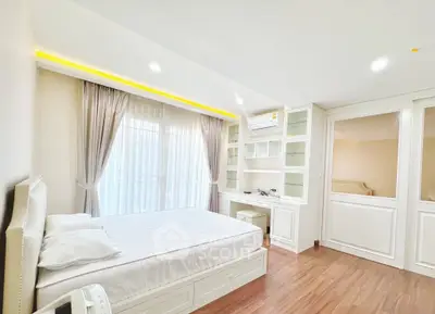 Bright and spacious bedroom with elegant built-in storage and large window