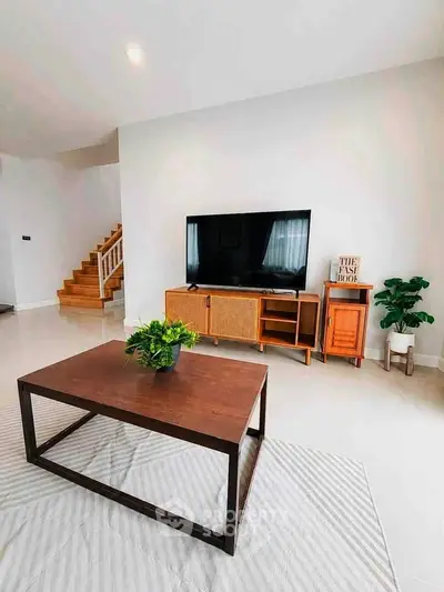 Modern living room with stylish furniture and large TV, showcasing a cozy and inviting atmosphere.