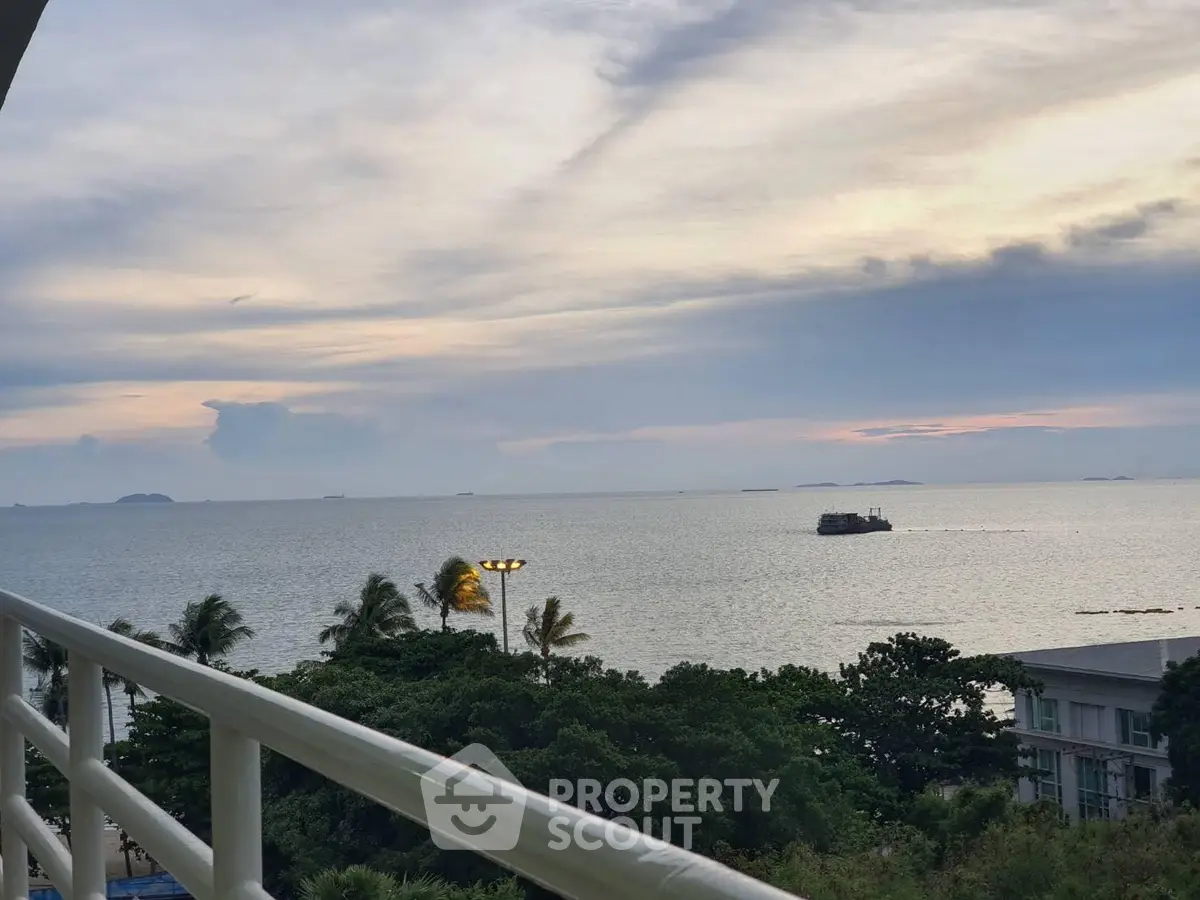 Stunning ocean view from balcony with lush greenery and serene horizon.