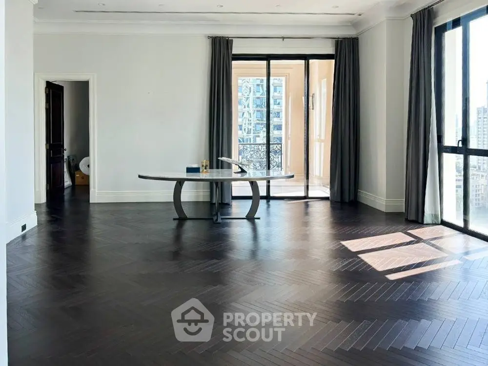 Spacious modern living room with elegant dark wood flooring and large windows.