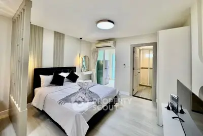 Modern bedroom with stylish decor and ensuite bathroom in a contemporary apartment.