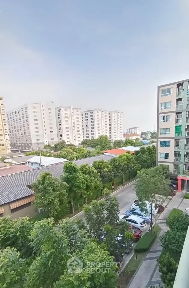 Scenic view of residential buildings and lush greenery from a high vantage point, showcasing urban living.
