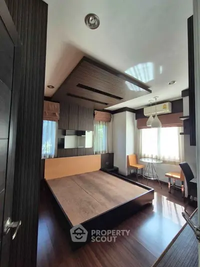Modern bedroom with stylish wood paneling and large windows for natural light.