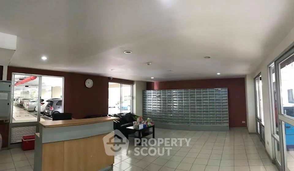 Spacious building lobby with mailboxes and seating area, ideal for welcoming guests.