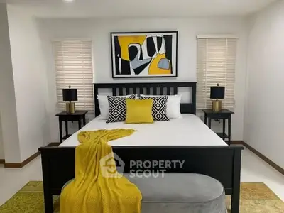 Modern bedroom with stylish decor and vibrant yellow accents, featuring a comfortable bed and contemporary artwork.