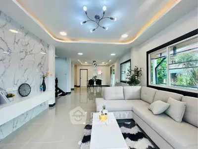 Spacious modern living room with elegant decor and large windows offering natural light.