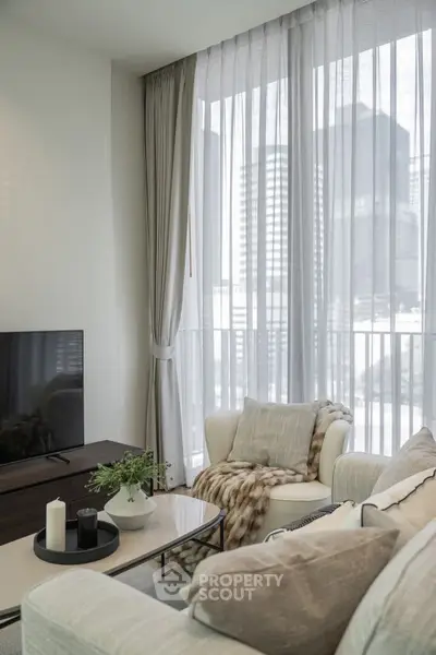 Elegant living room with modern decor and large windows offering city views.