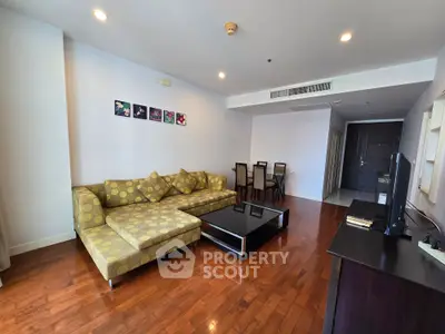 Spacious living room with modern decor and wooden flooring in a stylish apartment.