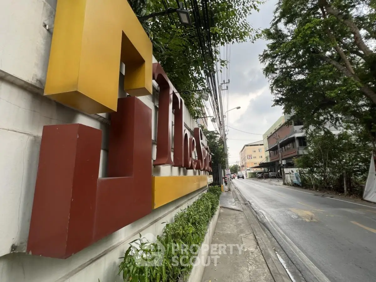Street view with modern building signage and lush greenery