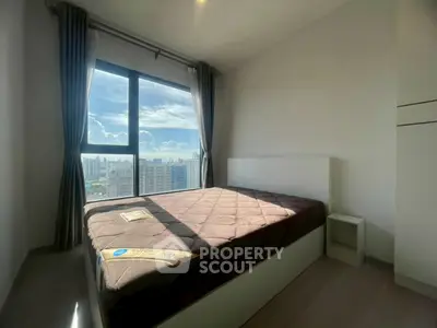 Bright bedroom with large window offering stunning city views, featuring a cozy bed and modern decor.